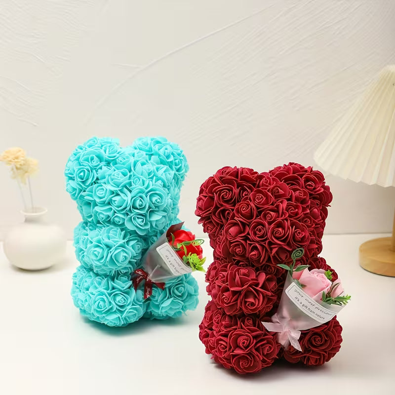 Two teddy bears made of rose petals, one blue and one red, on a white surface.